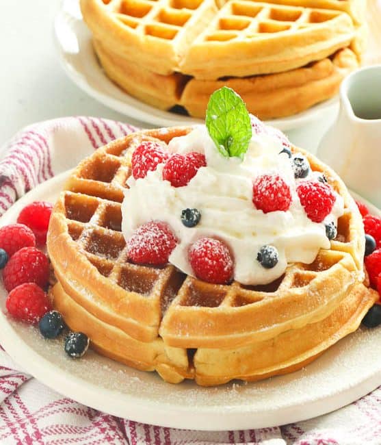 Homemade Waffles topped with whipped cream and berries